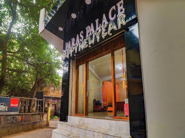 A building with a sign that reads 'PARAS PALACE' and a large glass entrance.