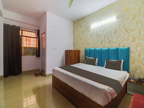 A hotel room with a bed, a wardrobe, a bedside table with a phone, and a curtain. - Hotel O Paras Palace (Jhansi)