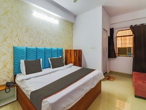 A hotel room with a bed, a bedside telephone, a window with curtains, and a wall with a patterned wallpaper. - Hotel O Paras Palace (Jhansi)