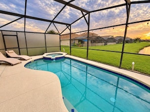 Piscina com hidromassagem, rodeada por uma área coberta com espreguiçadeiras.
