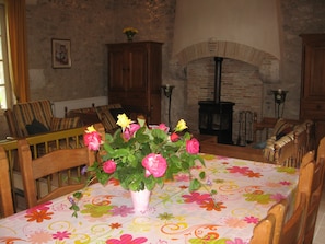 A dining area with a floral tablecloth, wooden chairs, and a vase of flowers. - New Listing (Villeréal)
