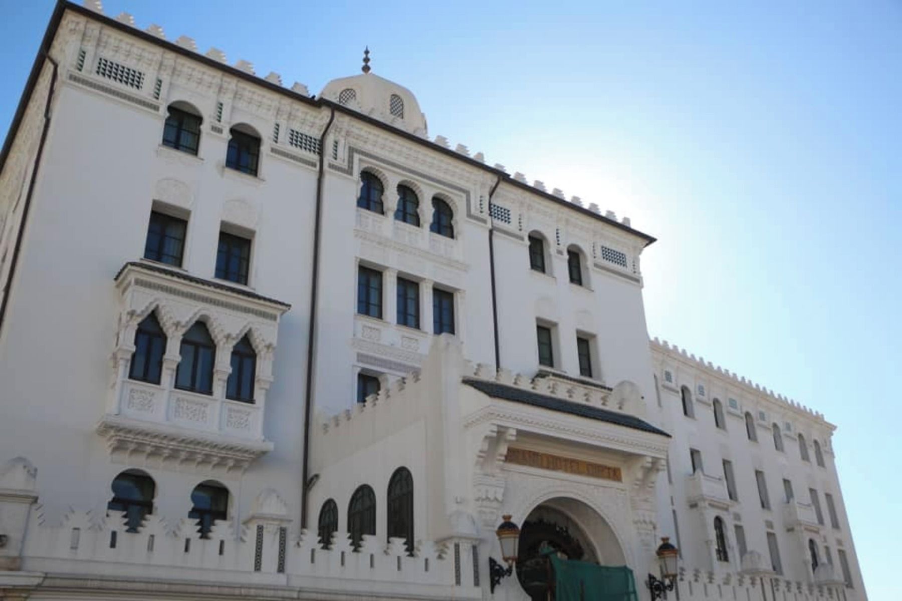 A white building with multiple windows and a dome.