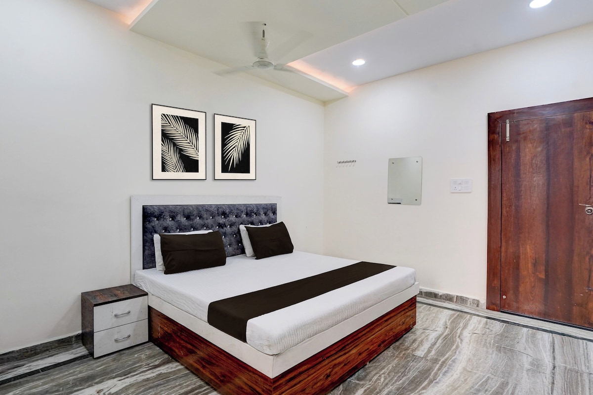 A bedroom with a bed, bedside tables, a wardrobe, and artwork on the wall.