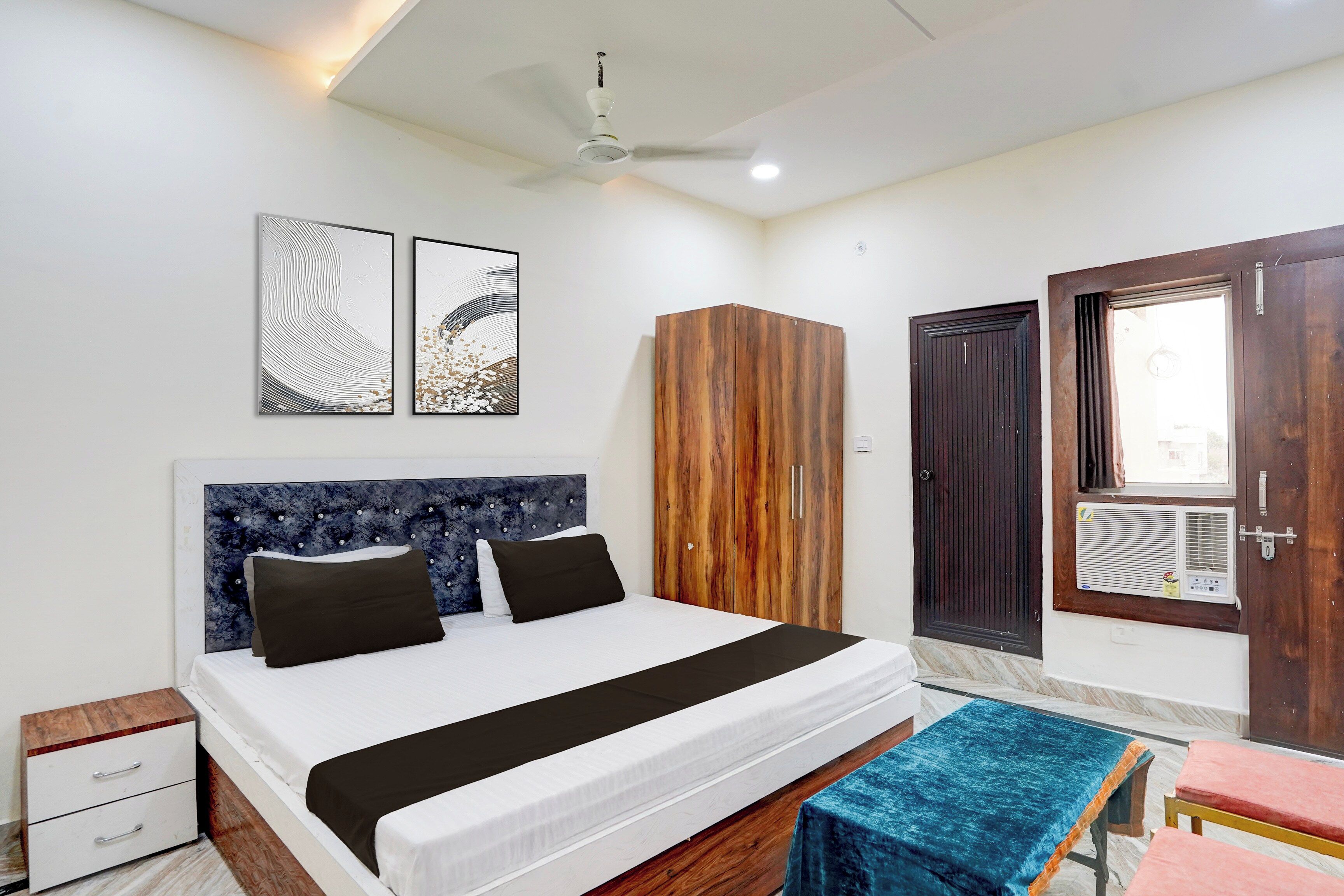 A bedroom with a bed, a wardrobe, a door, and a ceiling fan.