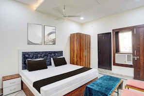 Un dormitorio con cama, armario, puerta y ventilador de techo.
