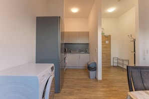 A compact kitchen with a built-in oven, a sink, and a microwave. - New Listing (Mainz)