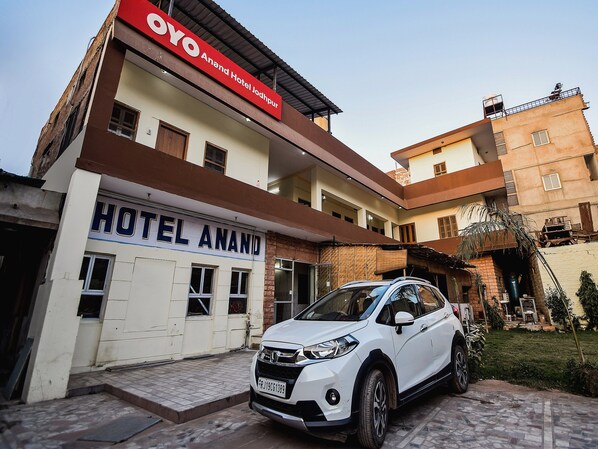 A white SUV parked in front of Hotel Anand with a clear sky. - Hotel O Anand Hotel Jodhpur (Jodhpur)
