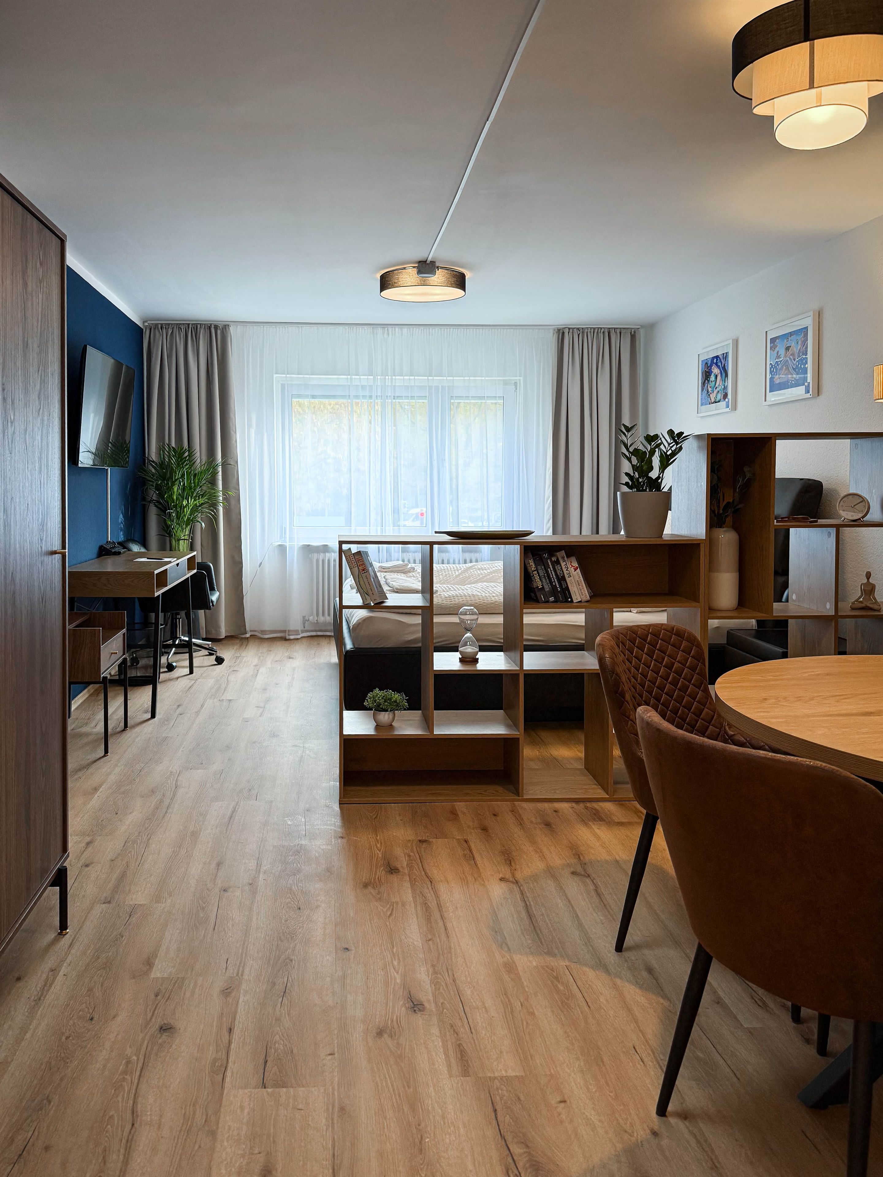 Ein modernes Wohnzimmer mit Holzboden, einem runden Esstisch, einer Couch und einem Couchtisch.