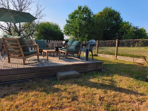 A wooden deck with outdoor furniture, including chairs and a table, surrounded by a chain-link fence. - New Listing (Le Gault-du-Perche)