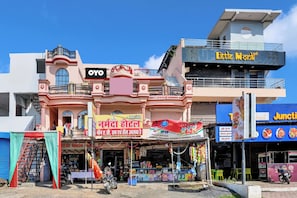 A multi-story building with various shops on the ground floor, including a visible sign for a hotel named 'OYO'. - HOTEL O MAA NARMADA (Jabalpur)