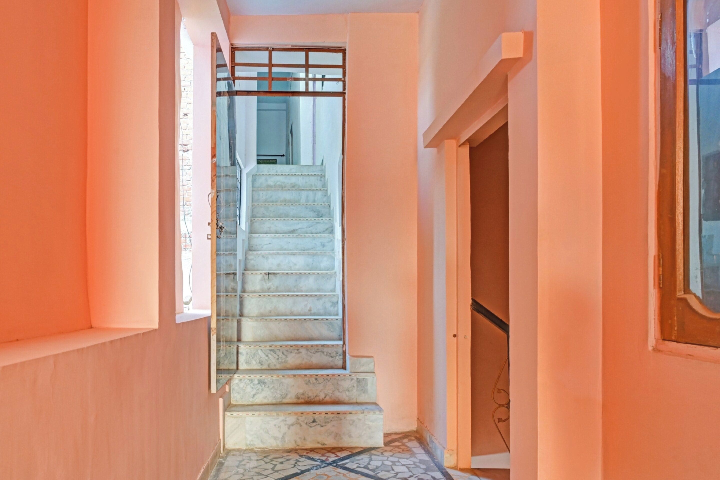 Una escalera con escalones de mármol que sube a un piso superior.