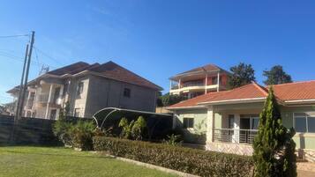 Un barrio residencial con casas de dos pisos, un césped cuidado y un cielo azul despejado.