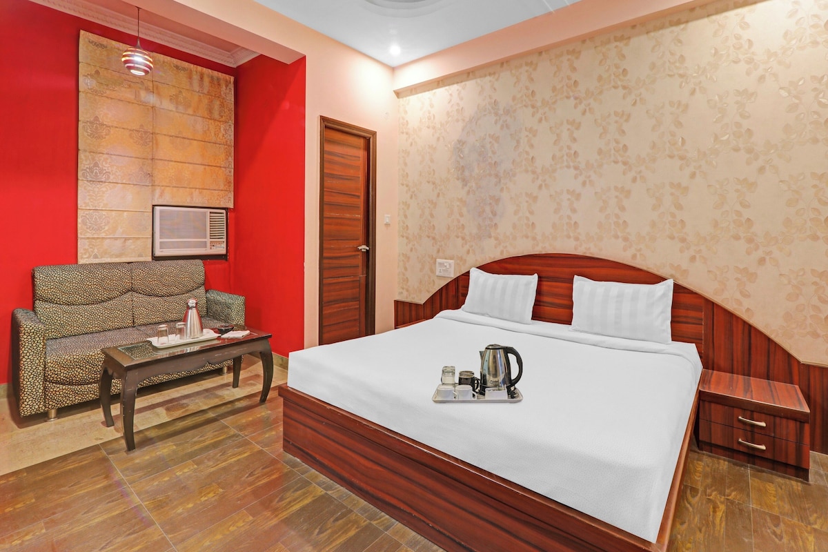 Habitación de hotel con una cama grande, un sofá, una mesa de centro y una decoración de pared.