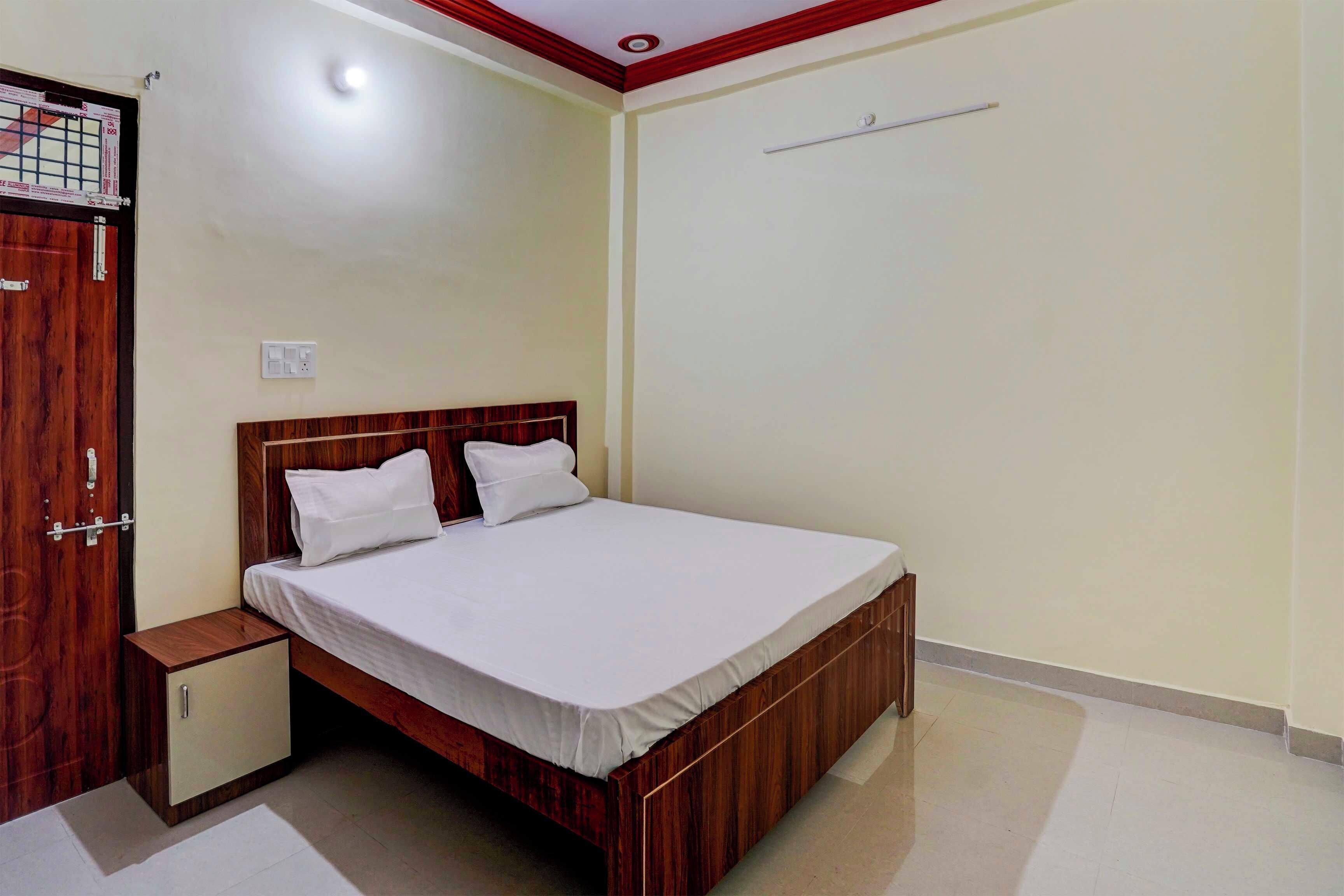 Habitación individual con una cama, cabecera de madera, mesita de noche y armario.
