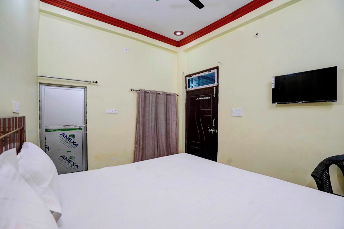 A hotel room with a bed, a wardrobe, a television, and a ceiling fan.