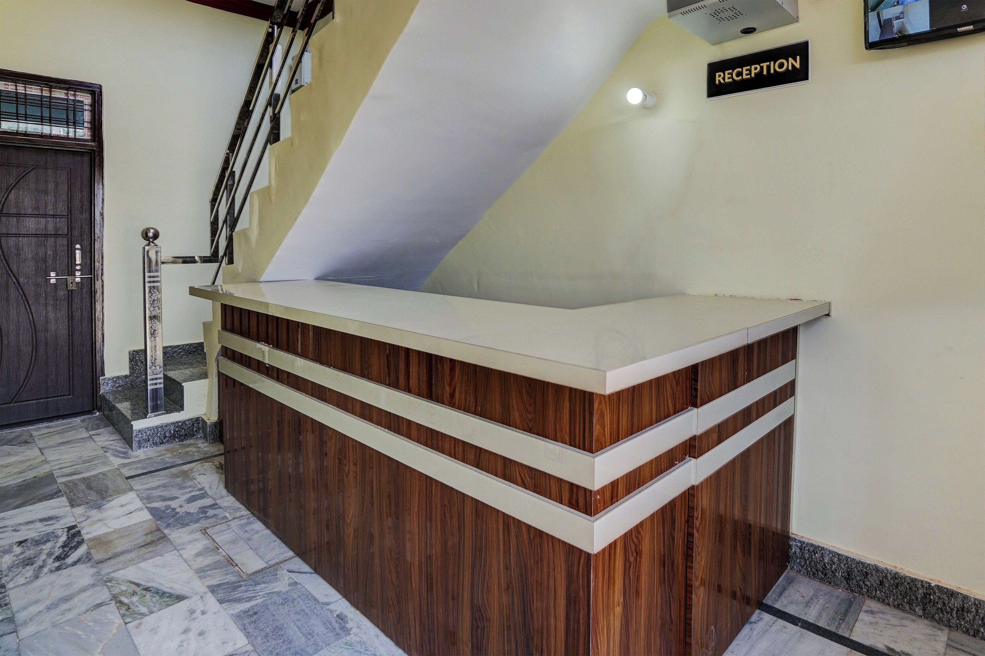 Un mostrador de recepción de diseño moderno, una escalera y un cartel de recepción.