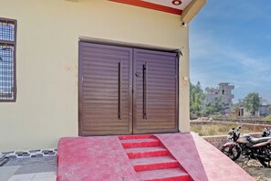 A building with a large, closed double door and a set of red stairs leading up to the entrance. - Hotel O Home Hotel Star Galaxy (Kanpur)
