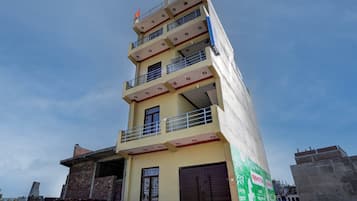 A multi-story building with balconies and a flat roof.
