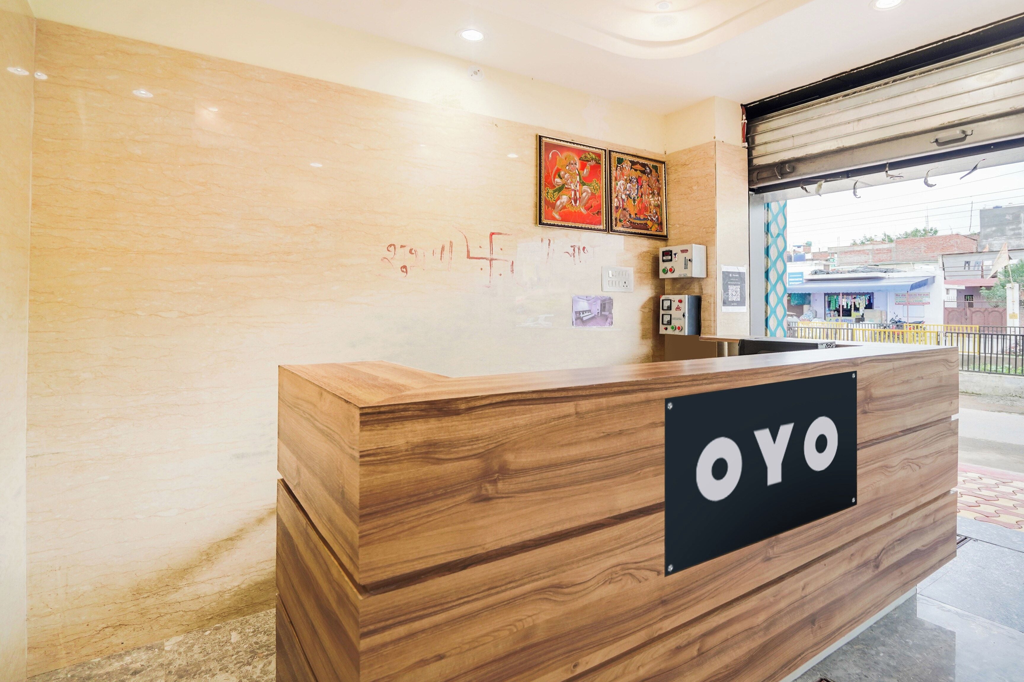 A reception desk with a wooden finish and a black sign that reads 'OYO'.
