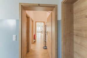 A hallway with wooden doors, a fire extinguisher, and a coat rack. - New Listing (Mainz)