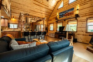 Ein rustikales Blockhaus-Interieur mit Wohnbereich, Küche und Essbereich.