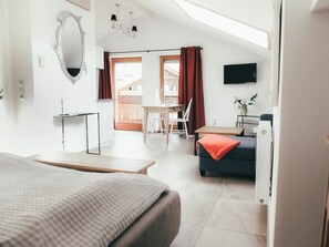 A modern hotel room with a bed, a desk, a chair, and a sofa. - House Luna - Apartment Luna 8 (Schwangau)