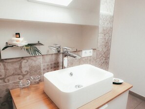 A modern bathroom with a large rectangular sink, a mirror above it, and a shelf with toiletries. - House Luna - Apartment Luna 8 (Schwangau)