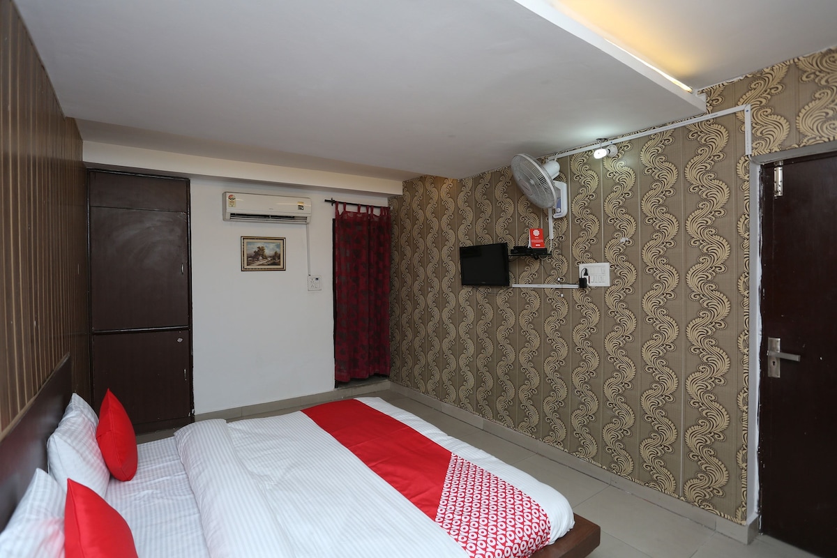 Une chambre d’hôtel équipée d’un lit, d’un appareil de climatisation, d’une télévision et d’une porte.