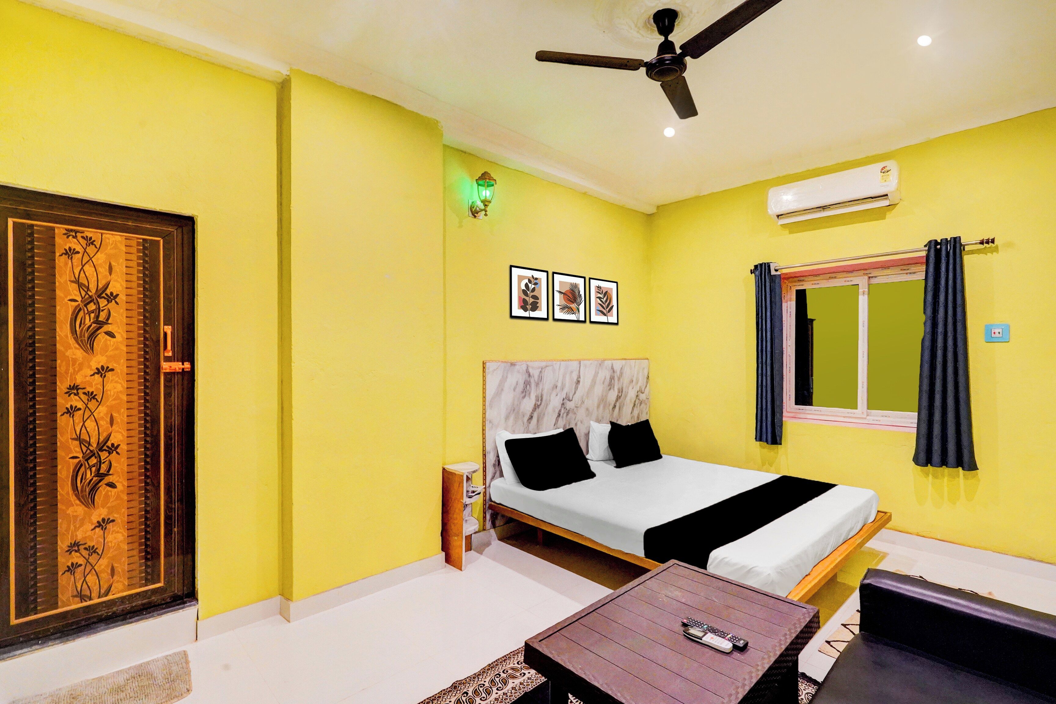 A room with a bed, a ceiling fan, a window with curtains, and a wall-mounted air conditioner.