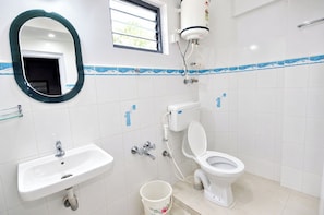 Een badkamer met toilet, wastafel en boiler.