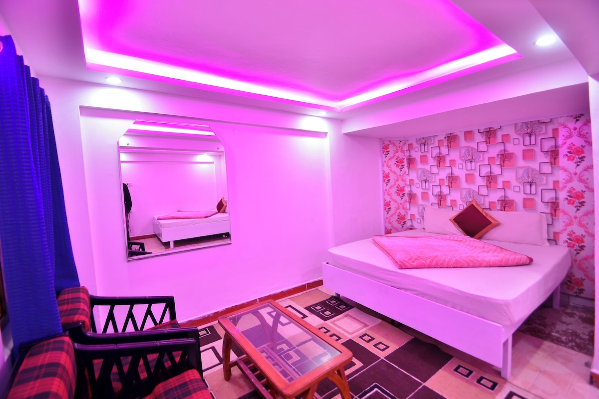 Een kamer met een bed, een spiegel, een bank en een klein tafeltje.