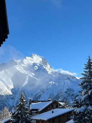 A mountain with snow-covered peaks, a wooden cabin, and evergreen trees. - Appartement cosy – aux 2 Alpes (Les Deux Alpes)