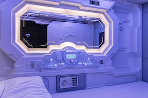 Ein Zimmer mit einem Bett, einer Bedienkonsole und einem digitalen Bildschirm.