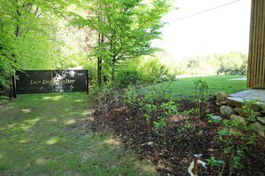 A garden with a sign reading 'Der Diselfalter' and a stone wall. - New Listing (Lieschen)