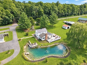 Uma casa com um deck espaçoso, piscina e um gazebo.