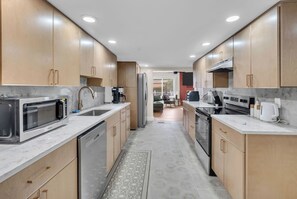 A modern kitchen with built-in appliances, wooden cabinets, and a central island.