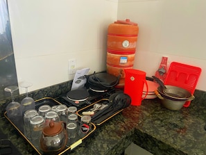 A kitchen counter with various cooking utensils, a kettle, and storage containers. - New Listing (Montes Claros)