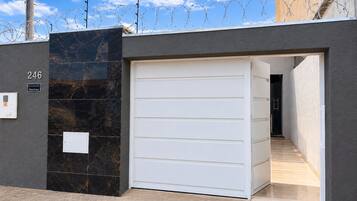 Una entrada cerrada con puerta de garaje, buzón y placa de número.