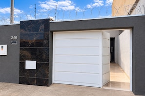A gated entrance with a garage door, a mailbox, and a number sign. - New Listing (Montes Claros)