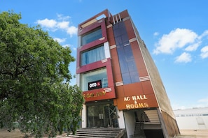 A multi-story hotel with a modern architectural design, featuring a prominent entrance with glass doors and a staircase leading to the lobby. - Hotel O S.S tower (Kanpur)
