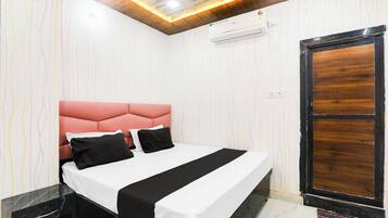 Una habitación de hotel con una cama, una puerta de madera y un piso de mármol.