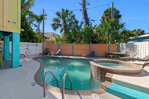 A swimming pool with a hot tub, surrounded by a wooden fence, and palm trees in the background. - Siesta Key | Pool, Spa & Flexible 1-2 Bedroom Lock-Off (Siesta Key)