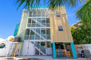 A multi-story building with a pool, outdoor seating, and a staircase. - Siesta Key | Pool, Spa & Flexible 1-2 Bedroom Lock-Off (Siesta Key)