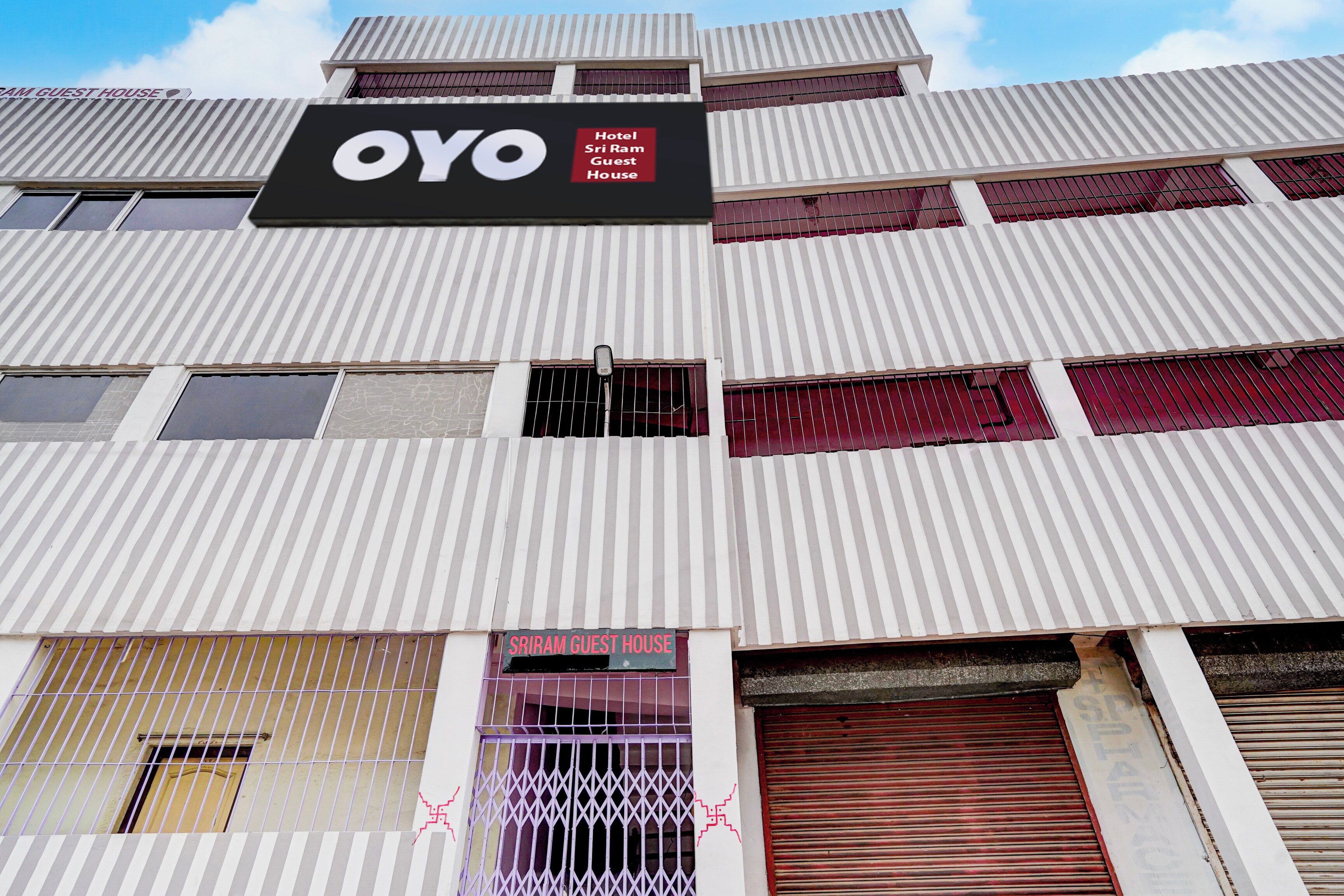 Un edificio de hotel con un letrero que dice 'OYO Hotel Sri Ram Guest House'.