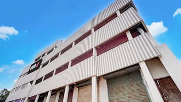 Un edificio de varios pisos con un diseño arquitectónico moderno, que presenta una serie de balcones y grandes ventanales.