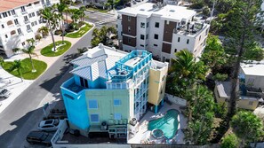 A multi-story hotel with a rooftop pool and a landscaped courtyard. - Siesta Key Beach | Heated Pool, Spa & Lock-Off Suite (Siesta Key)