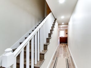 A staircase with white railings and wooden steps leading to a landing. - Spacious 6-bedroom house in serene Tulsa with cool AC (Tulsa)