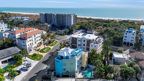 Un complejo hotelero frente al mar con varias construcciones, una piscina y vistas a la playa.