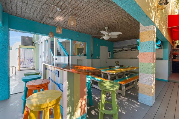 Una cocina vibrante con una isla grande, taburetes de bar y un ventilador de techo.
