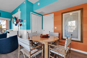 A dining area with a round table, striped chairs, and a large window with a framed picture. - Exclusive Second-Floor Retreat | Pool, Spa & Near Siesta Key Beach (Siesta Key)